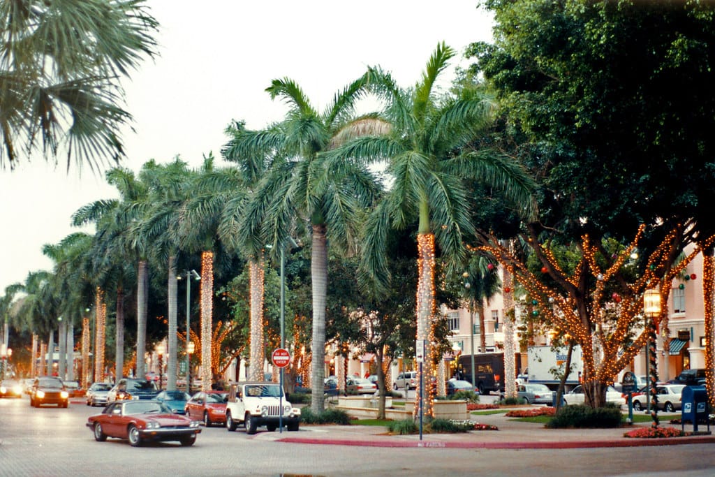 The fountain at Mizner Park in Boca Raton, framed by royal palms and pink Mediterranean-style buildings