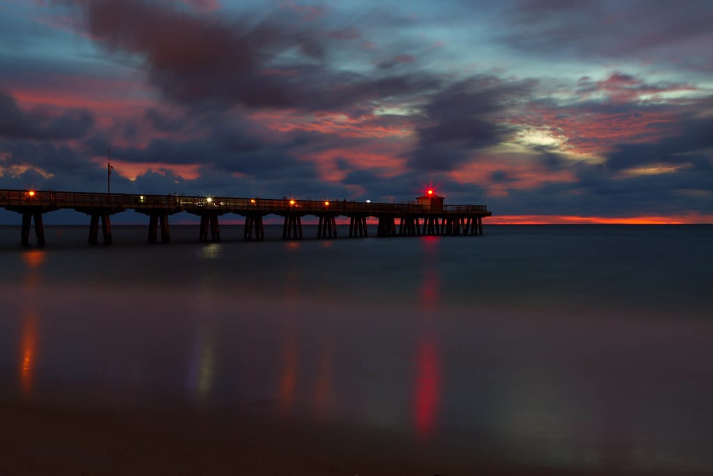Aerial view of the Fisher Family Pier in Pompano Beach reaching over turquoise water from the beach