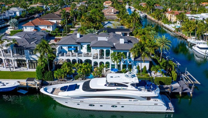 Waterfront estate with a large yacht at the dock